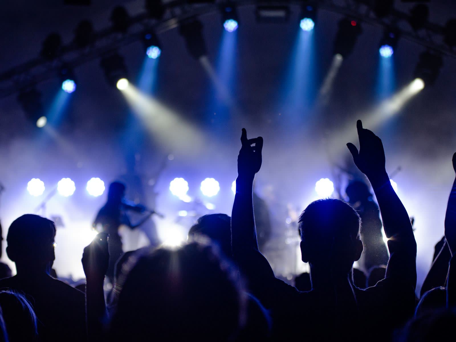 Une vaste foule de fans éclairée en bleu lors d'un spectacle live